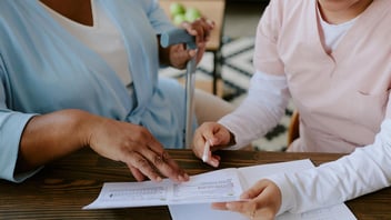 nurse and resident looking over paperwork