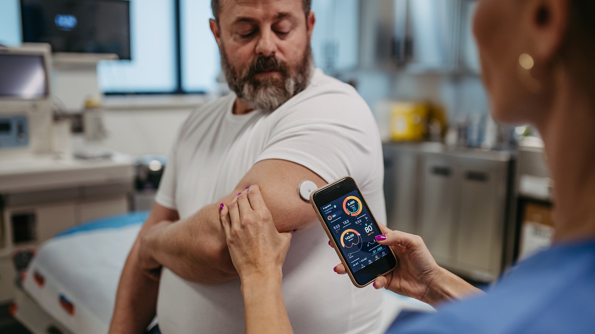 Man with diabetes being checked by nurse with handheld device