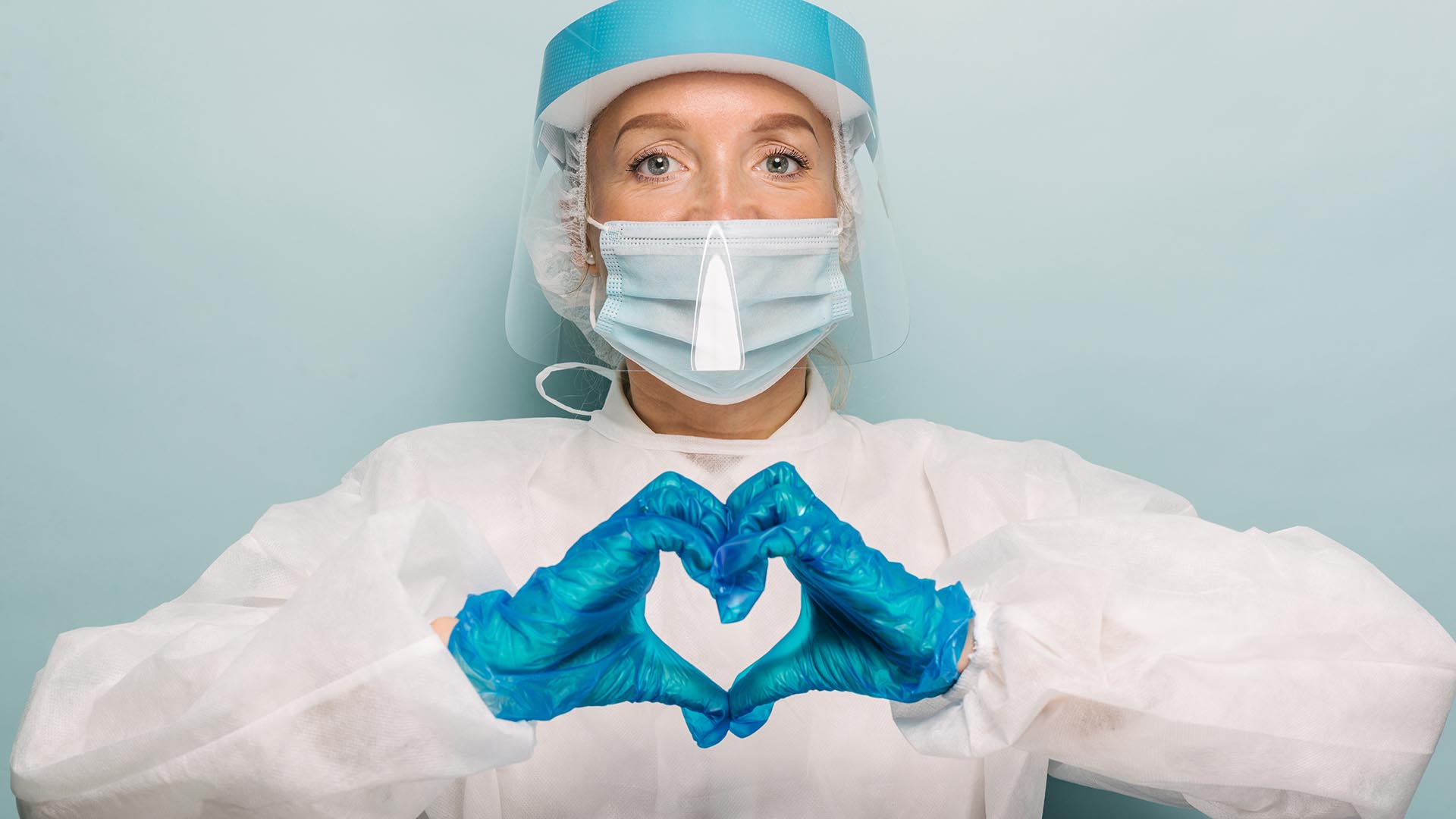 Nurse with PPE give ing a hand heart sign