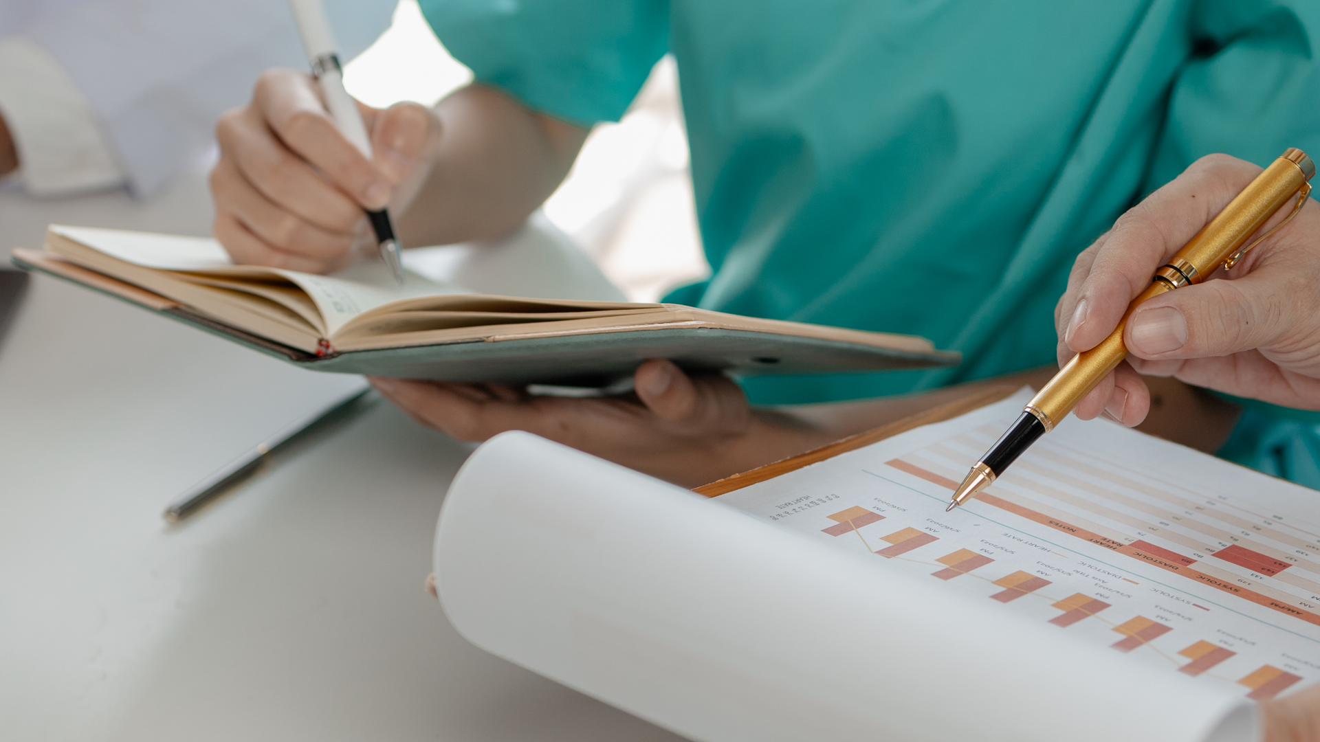 Close-up image of medical professional holding paper documents and medical records